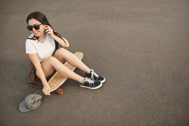 快乐俯视无忧无虑的时髦女孩戴着太阳镜 趴在地上魅力青少年年轻
