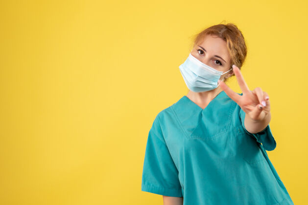 脸黄墙上年轻女医生穿着医疗服 戴着口罩的正面图人成人漂亮