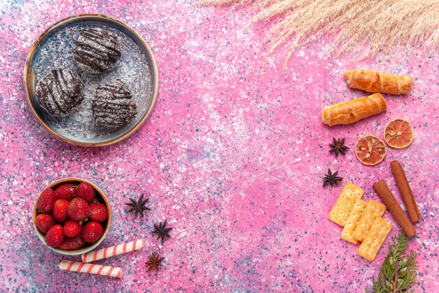 肉桂顶视图美味的巧克力蛋糕与百吉饼粉红色蛋糕盘子草莓