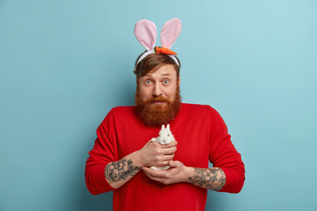 节日震惊的公兔耳朵抱着小兔子 准备复活节假期复活节兔子庆祝