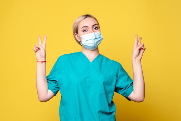 面具黄墙上年轻女医生穿着医用衬衫 戴着口罩的正面图年轻女医生胡子成人