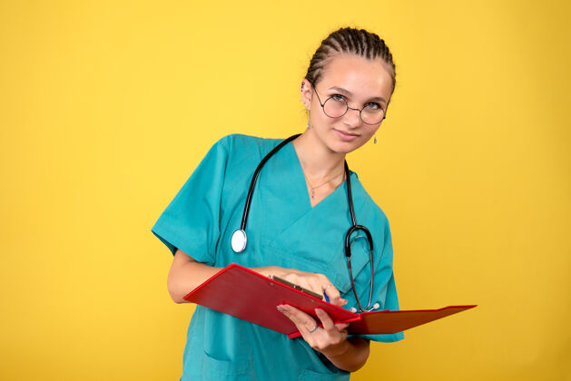 写作身穿医用衬衫的女医生在黄色墙上写笔记的正面图医疗护士医院