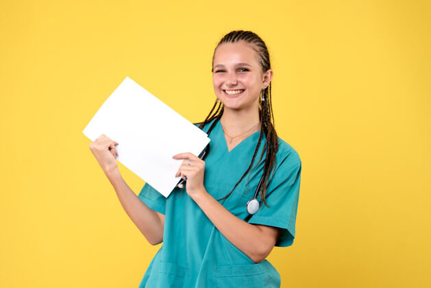 病毒身着医疗服的女医生的正面图 黄色的墙上有纸疾病快乐情绪
