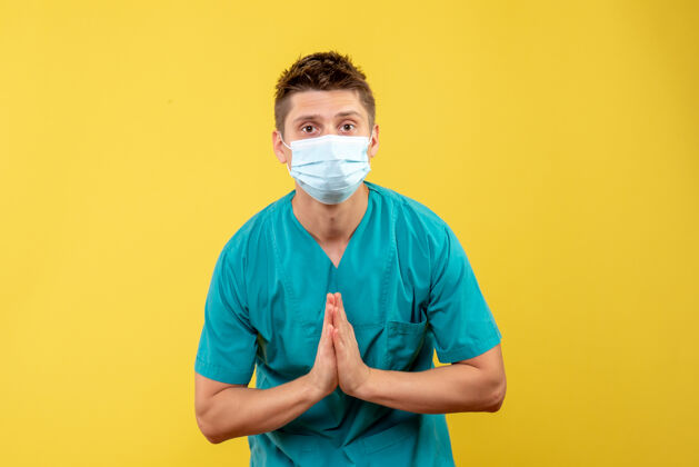 人黄墙上的男医生穿着医疗服 戴着无菌口罩肖像男性成人