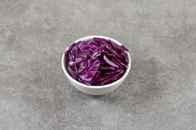 农业把红卷心菜切成片放在碗里 放在大理石桌上有机健康成熟的