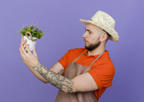 园艺笨手笨脚的男园丁戴着园艺帽捧着花盆看男性帽子空间