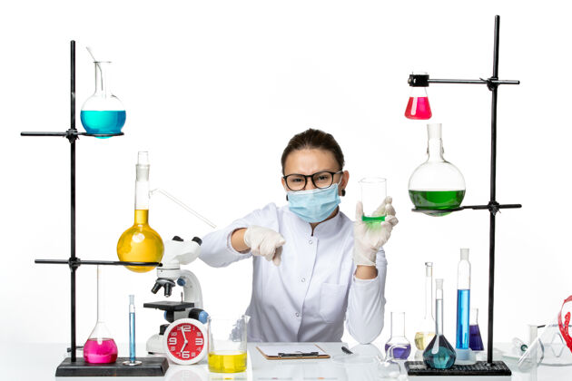 医院前视图穿着医疗服的女化学家 带面罩 背景为浅白色 飞溅实验室病毒化学covid-专业解决方案视图