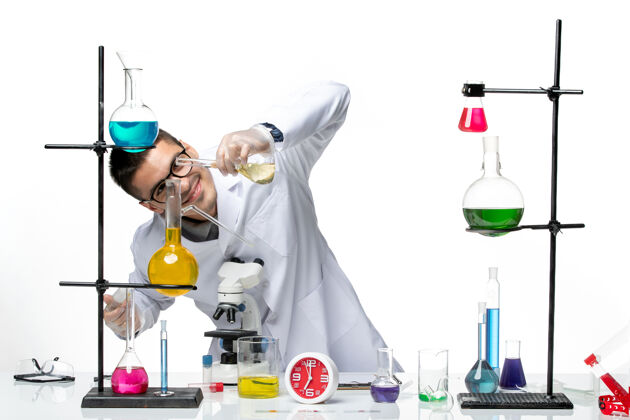 工作前视图穿着白色医疗服的男性化学家正在处理白色背景实验室病毒科学冠状病毒大流行的解决方案容器视图瓶子