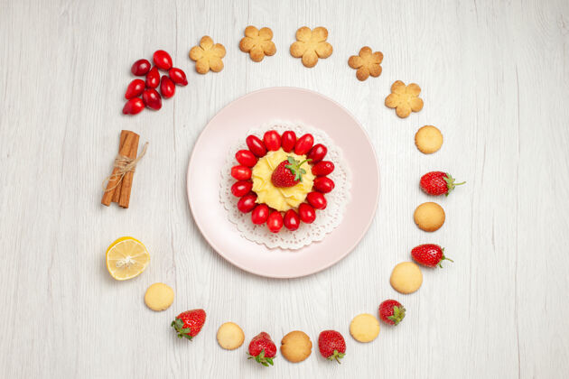 鲜花在白色的桌子上俯瞰美味的饼干和水果蛋糕鲜花茶框架