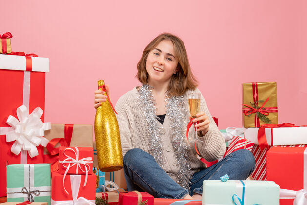 年份正面图年轻女性围坐在圣诞节礼物庆祝香槟人周围礼物