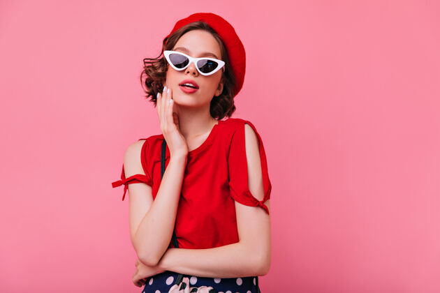 现代灵感来源于一个留着深色卷发的法国女孩穿着红色贝雷帽的高加索女人饶有兴致地看着她有趣女人室内