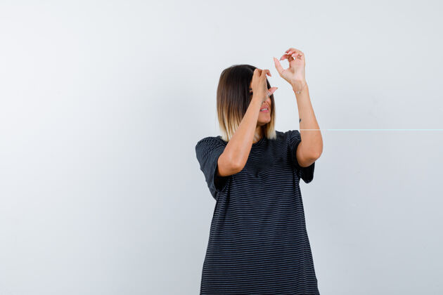 马球穿着马球衫的年轻女性用手指当望远镜 注视着前方清洁年轻亚洲人