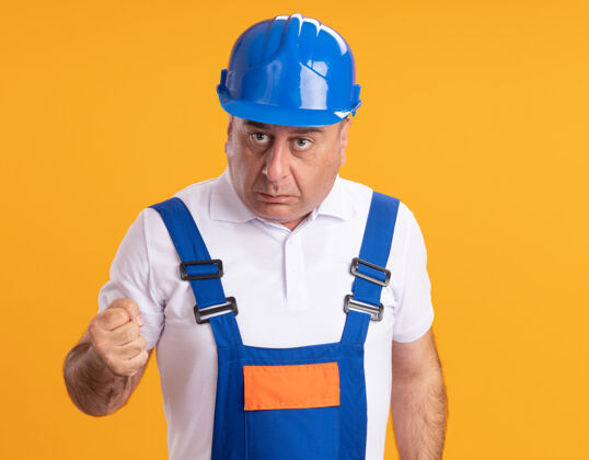 拳头焦急的白人成年建筑工人身着制服 拳头紧握橙色人焦虑制服