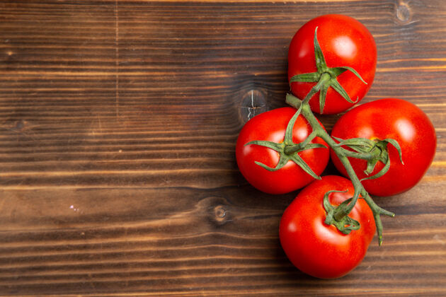 沙拉在棕色的木桌上俯瞰红色的西红柿和成熟的蔬菜香草健康素食