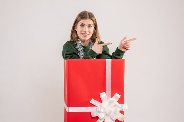 圣诞节礼物盒内年轻女性的正面图颜色丝带礼物