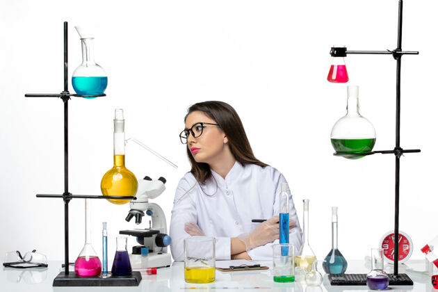 医生前视图穿着白色医疗服的女化学家在浅白色背景上工作和写笔记科学病毒冠状病毒-大流行实验室科学人套装