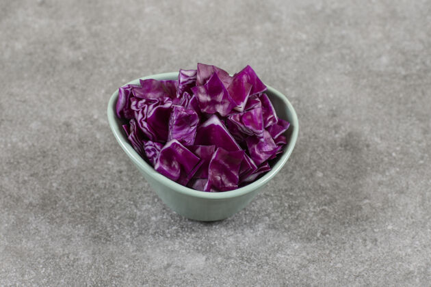 有机石桌上放着一碗紫白菜片切健康新鲜