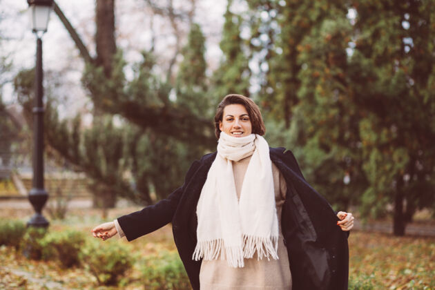 女孩公园里穿着冬天黑外套白围巾的女人的户外肖像优雅健康华丽