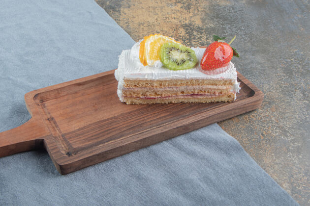 口感水果和奶油蛋糕片放在小木板上蛋糕美味风味