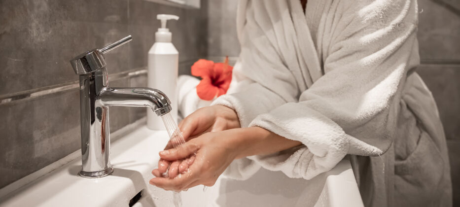 清洁一个穿着浴衣的女孩在浴室洗手的特写镜头浴室手清洗