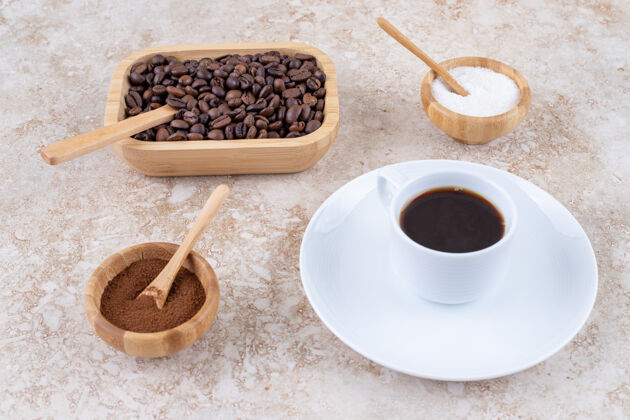 茶碟一小碗糖旁边的各种形式的咖啡芳香研磨杯子