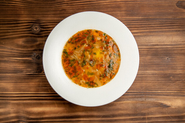 盘子俯瞰美味的蔬菜汤与绿色的棕色木桌上汤食品蔬菜餐调味料食物汤蔬菜
