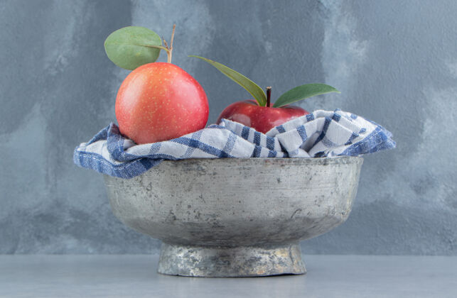 苹果一条毛巾和苹果放在大理石上的金属碗里碗饮食多汁
