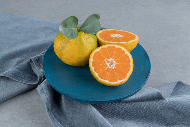 饮食橘子在蓝色的木板上 在一块布上 在大理石上配料健康美味