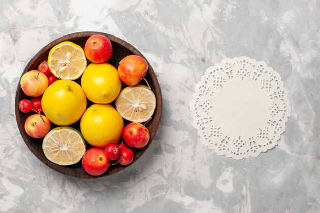整个顶视图新鲜柠檬整个和切片在白色的桌子上异国情调顶级柑橘
