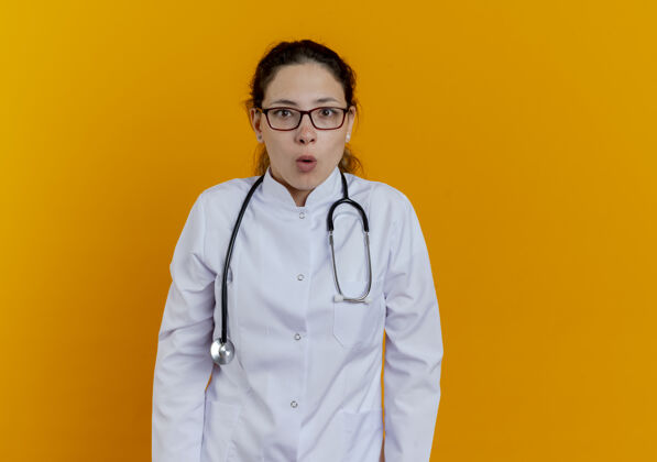 长袍年轻的女医生穿着医用长袍 戴着听诊器和眼镜 看上去与世隔绝医生医生年轻人