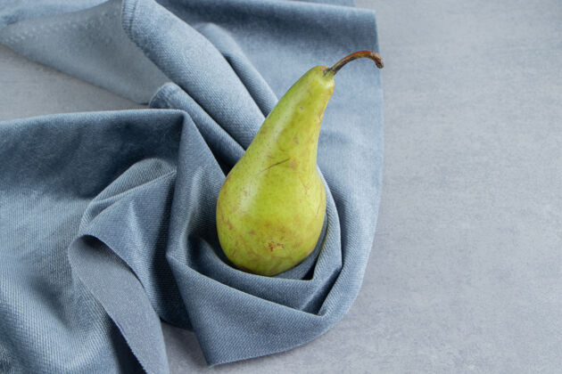梨一个梨在大理石上的一块布上多汁风味健康