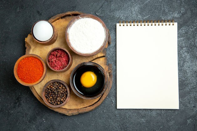 膳食顶视图不同的调味品与面粉记事本和鸡蛋的灰色空间面粉油漆紧固件