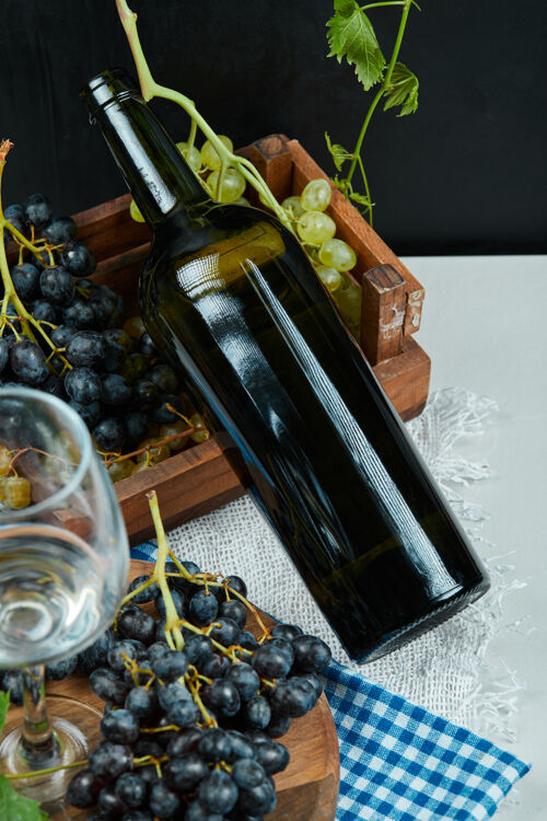 多汁一堆葡萄 一杯葡萄酒 一瓶放在白色的桌子上高质量的照片葡萄酒美味季节