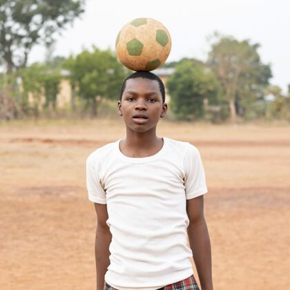 足球比赛一个拿着足球的非洲小孩孩子足球玩