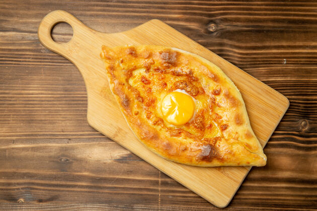 比萨饼俯瞰美味的鸡蛋面包烤在棕色的木桌上面包包烤早餐鸡蛋午餐美味晚餐