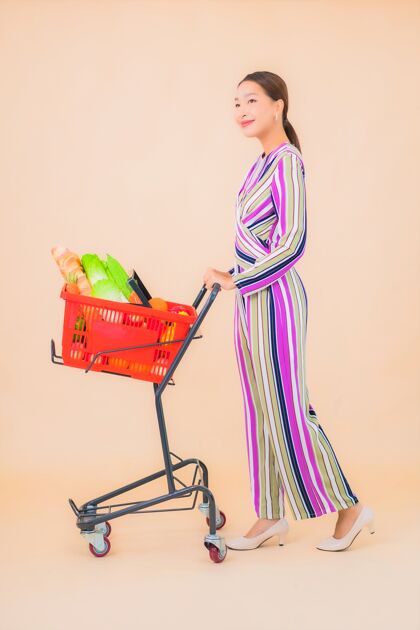 购物一幅美丽的亚洲年轻女子的肖像画 上面是超市的购物篮亚洲女人肖像