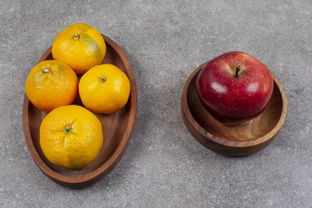 五颜六色木板上有红苹果和甜橘子健康团体水果