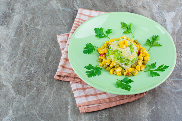 玉米把玉米沙拉放在盘子里 放在茶巾上 放在大理石上风味茶毛巾盘子