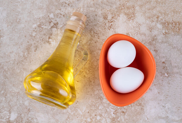 美味两个新鲜的白鸡蛋和一瓶玻璃油天然有机食物