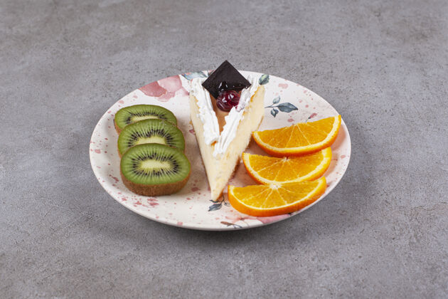 食品在盘子里放一片芝士蛋糕和水果奇异果蛋糕面包房