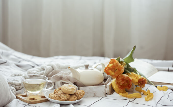 郁金香一杯茶 一个茶壶 一束郁金香和饼干躺在床上静物生活床舒适构图