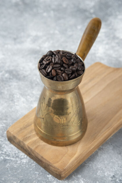 咖啡装满烤咖啡豆的咖啡壶放在木板上香味美食农作物