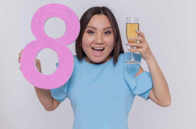 三月快乐和兴奋的亚洲女人拿着8号和一杯香槟庆祝女人白天