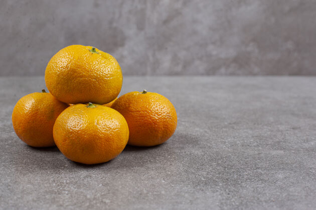 有机新鲜的甜橘子在灰色的表面堆柑橘板