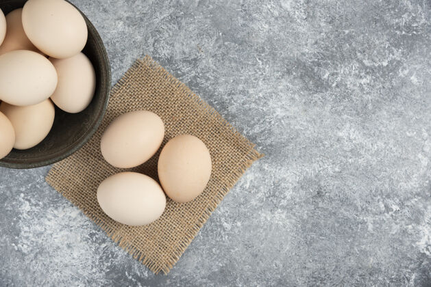 蛋白质在大理石表面放上一碗新鲜的有机生鸡蛋粗麻布天然烹饪