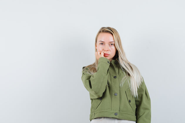 女性身着绿色夹克的年轻女性 牛仔裤聚焦镜头 正面视图牛仔裤夹克自然