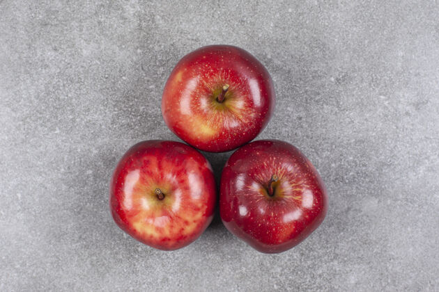 生的大理石表面有三个红苹果苹果新鲜有机