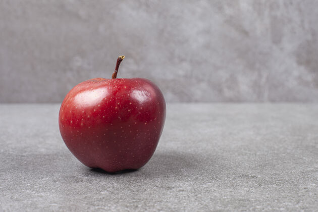 新鲜大理石表面只有一个红苹果生的有机成熟