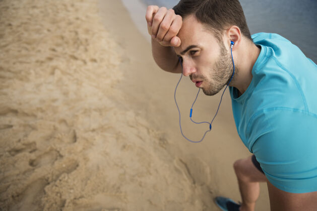 运动特写在海边慢跑的健康年轻人沙滩高视角焦点