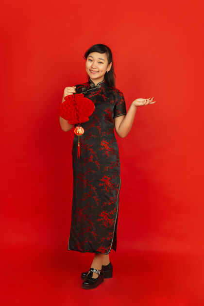 肖像2020年中国新年快乐红色背景上孤立的亚洲少女肖像穿着传统服装的女模特看起来很快乐 带着装饰微笑庆祝 节日 情感微笑庆祝文化